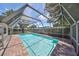 A pristine pool is showcased within a screened enclosure and brick patio at 3908 W Wallace Ave, Tampa, FL 33611