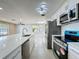 Modern kitchen with stainless steel appliances, white cabinetry, a large island, and an open layout at 7702 Ivory Ter, New Port Richey, FL 34655