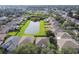 Aerial view showcasing a neighborhood with houses surrounding a pond at 5707 Butterfield St, Riverview, FL 33578