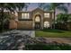 Two-story house with a tan exterior, two-car garage, and lush green lawn at 5707 Butterfield St, Riverview, FL 33578
