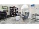 Home office features built-in shelving, two armchairs, and a round ottoman at 5707 Butterfield St, Riverview, FL 33578