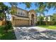 Two-story house with tan exterior, two-car garage, and a well-maintained lawn at 5707 Butterfield St, Riverview, FL 33578