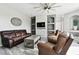 Relaxing living room with brown leather furniture, a stone fireplace, and a ceiling fan at 5707 Butterfield St, Riverview, FL 33578
