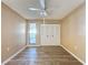 Bright bedroom with wood-look floors, ceiling fan, and sliding door to patio at 7702 Ivory Ter, New Port Richey, FL 34655