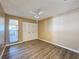 Bright bedroom with wood-look floors, ceiling fan, and sliding door to patio at 7702 Ivory Ter, New Port Richey, FL 34655