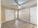 Bedroom featuring wood-look floors, ceiling fan and double door closet at 7702 Ivory Ter, New Port Richey, FL 34655