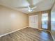 Bright bedroom with wood-look floors, ceiling fan, and sliding door to patio at 7702 Ivory Ter, New Port Richey, FL 34655