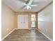 Bright bedroom with wood-look floors, ceiling fan and sliding door to patio at 7702 Ivory Ter, New Port Richey, FL 34655