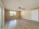 Spacious living area with wood-look flooring and ceiling fan at 7702 Ivory Ter, New Port Richey, FL 34655