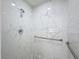 Large walk-in shower with marble-look tile and grab bars at 7702 Ivory Ter, New Port Richey, FL 34655