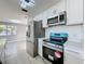 Modern kitchen with stainless steel appliances and island at 7702 Ivory Ter, New Port Richey, FL 34655