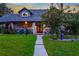 Evening view of inviting front porch with blue railing and landscaping at 1810 S Valrico Rd, Valrico, FL 33596