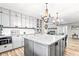 Spacious kitchen with an island, gray cabinets, and a large chandelier at 1810 S Valrico Rd, Valrico, FL 33596