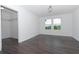 Bedroom with hardwood floors, two windows, and walk-in closet at 10813 Rolling Moss Rd, Tampa, FL 33647