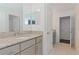 Bright bathroom with granite countertop, gray cabinets, and a double vanity at 10813 Rolling Moss Rd, Tampa, FL 33647