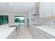 Modern kitchen features gray cabinets, quartz countertops, and a tile backsplash at 10813 Rolling Moss Rd, Tampa, FL 33647