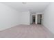 Bright bedroom with light gray carpet and access to hallway at 10813 Rolling Moss Rd, Tampa, FL 33647