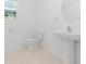 Clean bathroom with pedestal sink, toilet, and tiled floor at 10813 Rolling Moss Rd, Tampa, FL 33647