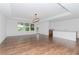 Spacious living room with wood-look flooring and access to balcony at 10813 Rolling Moss Rd, Tampa, FL 33647
