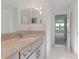 Clean bathroom with granite countertop, gray cabinets, and a double vanity at 10813 Rolling Moss Rd, Tampa, FL 33647