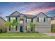 Two-story house with a neutral color palette, blue shutters, and palm trees at 10813 Rolling Moss Rd, Tampa, FL 33647