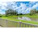 Serene pond view from backyard with lush landscaping at 10813 Rolling Moss Rd, Tampa, FL 33647