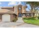 Brick home with a two-car garage, landscaping, and a walkway at 833 Ponce De Leon Dr, Tierra Verde, FL 33715
