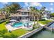 Luxury home with a pool, patio furniture, and boat dock at 833 Ponce De Leon Dr, Tierra Verde, FL 33715