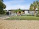 Renovated home with detached garage, fenced yard, and gravel driveway at 9913 Alavista Dr, Gibsonton, FL 33534
