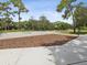 Basketball court with wood-chip surface and surrounding trees at 9913 Alavista Dr, Gibsonton, FL 33534