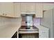 Stainless steel range, microwave hood, and white cabinets in this kitchen at 401 Dorchester Pl # 58, Sun City Center, FL 33573