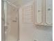 Bathroom with shower, linen cabinet, and floral wallpaper at 401 Dorchester Pl # 58, Sun City Center, FL 33573