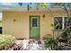 Front door view of a light yellow house with a green door at 401 Dorchester Pl # 58, Sun City Center, FL 33573