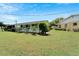 Spacious backyard with lush grass and tropical plants at 401 Dorchester Pl # 58, Sun City Center, FL 33573