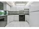 Modern kitchen with white cabinets, black appliances, and ample counter space at 1655 S Highland Ave # J390, Clearwater, FL 33756