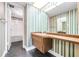 Bathroom with a vanity, striped wallpaper, and a bathtub at 1655 S Highland Ave # J390, Clearwater, FL 33756