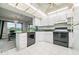 Bright kitchen features white cabinets, black appliances, and a breakfast bar at 1655 S Highland Ave # J390, Clearwater, FL 33756