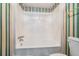Clean bathroom with a shower/tub combo and striped wall decor at 1655 S Highland Ave # J390, Clearwater, FL 33756