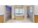 Bright bathroom featuring a soaking tub, walk-in shower, and double vanity with neutral finishes at 617 Islebay Dr, Apollo Beach, FL 33572