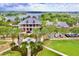 Aerial view of the clubhouse with a red truck parked in front, lush landscaping, and scenic lake backdrop at 617 Islebay Dr, Apollo Beach, FL 33572
