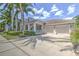 Charming single-story home featuring a well-manicured lawn, covered porch, and three-car garage at 617 Islebay Dr, Apollo Beach, FL 33572