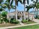 Charming home with a well-manicured lawn, lush landscaping, and inviting front porch, surrounded by palm trees at 617 Islebay Dr, Apollo Beach, FL 33572