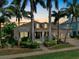 Charming two-story home at sunset with a well-manicured lawn and lush landscaping at 617 Islebay Dr, Apollo Beach, FL 33572