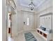 Bright foyer with a decorative light fixture, bench, and tiled floors at 617 Islebay Dr, Apollo Beach, FL 33572