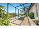 Waterfront lanai with travertine flooring and relaxing seating area, perfect for enjoying the peaceful canal view at 617 Islebay Dr, Apollo Beach, FL 33572