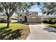 Two-story house with tan siding, large driveway, and landscaped yard at 13951 Caden Glen Dr, Hudson, FL 34669