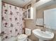 Bathroom with floral shower curtain, pedestal sink and toilet at 13951 Caden Glen Dr, Hudson, FL 34669