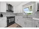 Modern kitchen with white cabinets and herringbone backsplash at 5805 8Th Avenue W Dr, Bradenton, FL 34209
