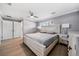 Main bedroom with light wood platform bed, ceiling fan, and double doors to closet at 5805 8Th Avenue W Dr, Bradenton, FL 34209