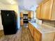 Galley kitchen with wood cabinets and laminate floor at 14141 11Th St, Dade City, FL 33525